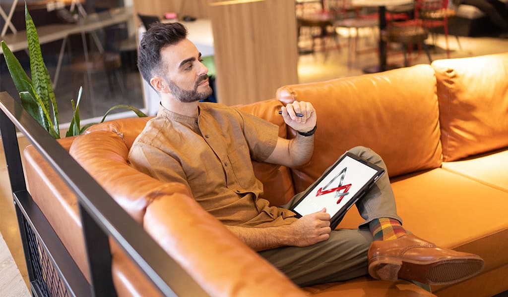 Man sitting on couch with tablet