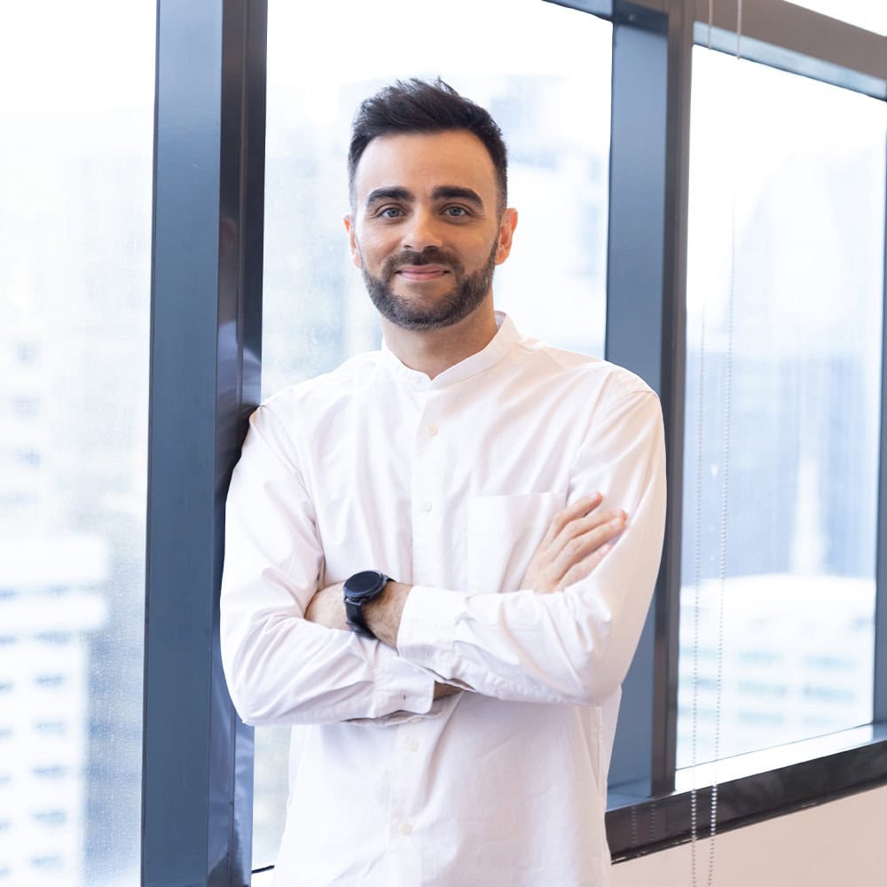 A smiling man dressed in white.